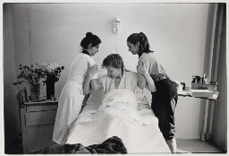 Een vrijwilligster helpt een verpleegster in een ziekenhuis. 1981