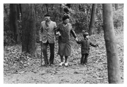 Een ouder echtpaar lopen met hun kleinkind in het bos. 198?