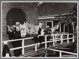 Vrouwen in klederdracht hangen de was op 194?
