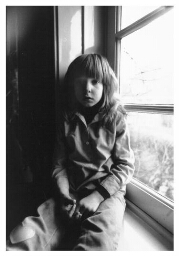 Een allochtoon meisje zit in een vensterbank. 198?