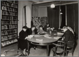 Bezoekers van de openbare leeszaal aan een leestafel. 1949
