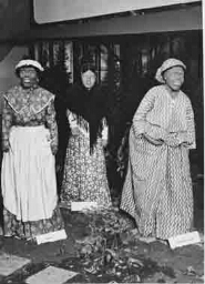 Detail van de stand van de afdeling 'De vrouw in de mode': 'Vrouwelijke Kleederdrachten v/d Provincies en Oost en West Indië' op de tentoonstelling 'De Nederlandse Vrouw 1898-1948' 1948