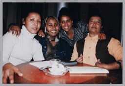Geheel rechts Lydia Booy, tweede van rechts Eleni Kikidane tijdens een Zamicasa (inloopcafé van Zami) met als thema Indonesië. 1998