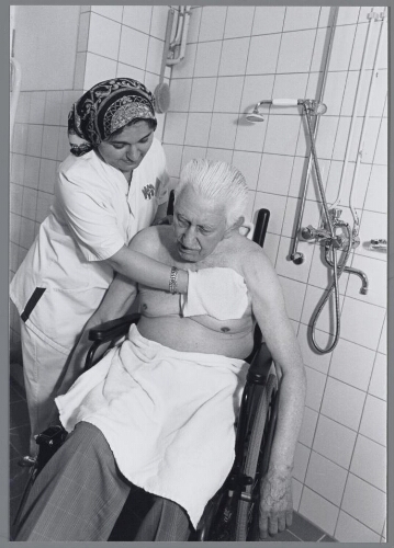 Vrouw van allochtone afkomst werkzaam in een verzorgingshuis, ze wast een man. 2000