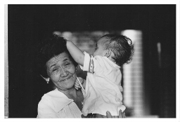 Oudere vrouw, werkzaam als dienstmeisje, met kind. 1984