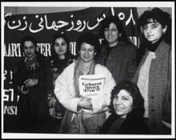 Zes vrouwen poseren voor een spandoek met de tekst: 'Lang leve 8 maart: internationale vrouwendag 199?