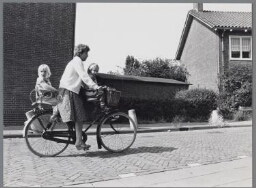 Een moeder met haar kinderen op de fiets. 1982