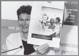 Nel van Dijk, directeur van het Landelijk Bureau Leeftijdsdiscriminatie met een 'verknipte' reclame van Stibbe waarbij de koppen zijn veranderd in vrouwen en allochtonen 2003