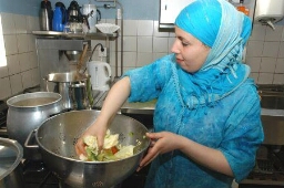 Vrouw met hoofddoek aan het koken tijdens Vrouweneten, maandelijkse bijeenkomst met diverse activiteiten 2007