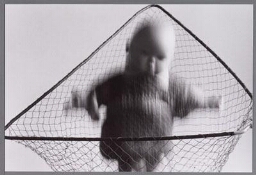 Verbeelding van kinderopvang: babypop in vangnet. 1989