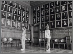 Twee vrouwen bekijken de geschilderde portretten van mannen die college gaven aan de universiteit van Utrecht. 1990