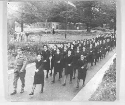 Het Vrouwen Hulp Korps marcheert in colonne door een park in Engeland. 194?