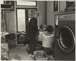Vrouw doet haar was in de wasserette bij Thea. 1984