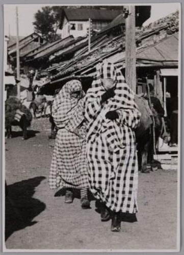 Vrouwen met abaya en sluier die het gehele gezicht bedekt lopen over straat in Sarajevo. 193?