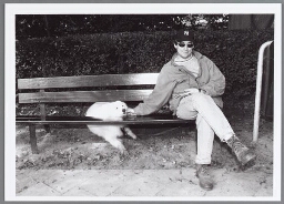 Bezoeker, samen met hond, in het Amsterdamse Vondelpark op een bank. 1996