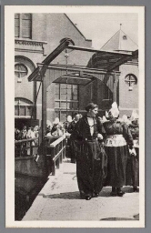 Mannen en vrouwen in Volendamse klederdracht bij ophaalbrug. 1900?