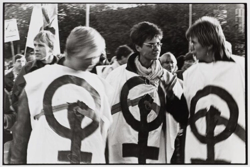 Demonstratie tegen kernwapens, Vrouwen voor Vrede dragen schorten waarop vrouwentekens en gebroken geweren geschilderd zijn. 1983