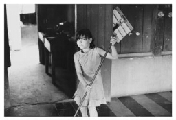 Een kind dweilt de vloer. 1984