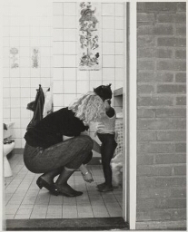 Medewerkster kinderopvang met meisje. 1984