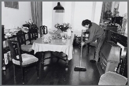 Illustraties bij het thema 'Wie zorgt er voor het huishouden als er geen huisvrouwen meer zijn ?' Vrouw veegt de vloer aan in de huiskamer. 1989