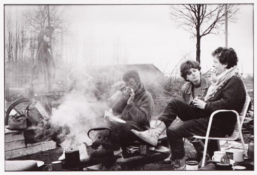 Vrouwen zitten bij het kampvuur in het Vrouwenvredeskamp bij vliegbasis Volkel. 1984