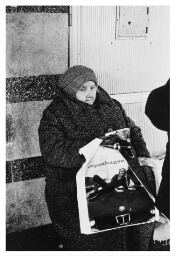 Vrouw met dikke winterkleding en plastic tas. 1982