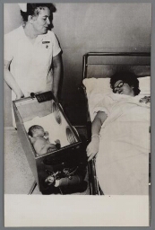 Vrouw met kraamverpleegster en haar kind in een couveuse 1968