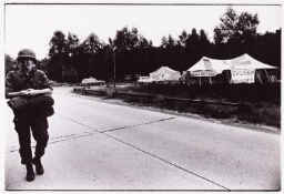 Militair loopt langs het Vrouwenvredeskamp bij vliegbasis Soest. 1982