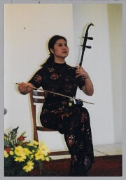 Muzikante bespeelt een strijkinstrument tijdens de viering van het Chinese Nieuwjaar bij Zami 1999