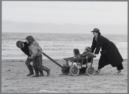 Illustratie bij artikel over bevolkingspolitiek: 'moet het krijgen van grote gezinnen in Nederland weer worden aangemoedigd ?' Op de foto moeder met vier kinderen aan het strand. 1990