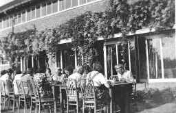 Vrouwen eten buiten aan lange tafels in de tuin van 'De Born' in de oorlogsjaren 1940-1943 194?