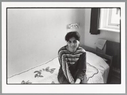 Vrouw zit op haar bed in het vrouwenopvangcentrum. 1985