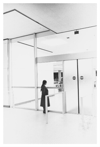 Een buitenlandse vrouw wacht in de aankomsthal van Schiphol. (1980)