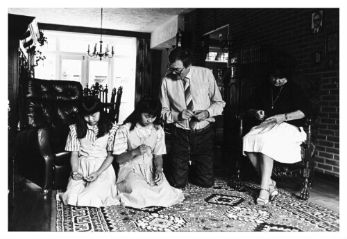 Een gezin bidt samen in de huiskamer. 198?