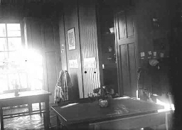Interieur van een kinderkamer met tafels en wiegje. 1925