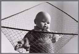 Verbeelding van kinderopvang: babypop in vangnet. 1990