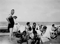 Johanna Westerdijk (zittend rechts van de twee staande personen links) aan zee bij Noordwijk 1935