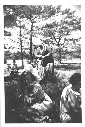 Groep jonge vrouwen zittend in een bos tijdens een vakantieclub 1935?