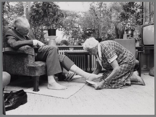 Vrouw verzorgt haar man thuis. 1986