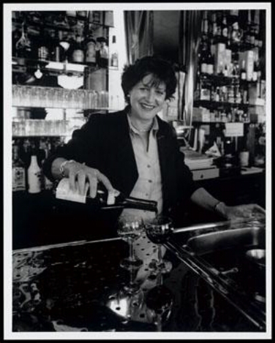Portret van Mieke Martelhof (1947), eigenares van café Vivelavie in Amsterdam, aan het werk in haar café 1998