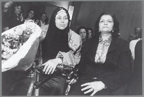 Discussie 'hoe vinden vrouwen(-bewegingen) hun weg tegen de verdrukking in ?'  Afghaanse vrouw, net in Nederland aangekomen, naast haar mevrouw Parvin Shahbazy (?) van het platform Iraanse vluchtelingen organisatie Nederland. 2001