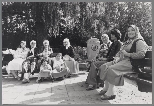 Turkse vrouwen en kinderen zitten op een bank. 1981