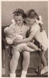 Kiekje van twee zusjes met hun baby-broertje of-zusje. 195?