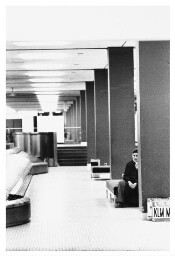 Een buitenlandse vrouw wacht in de aankomsthal van Schiphol. (1980)