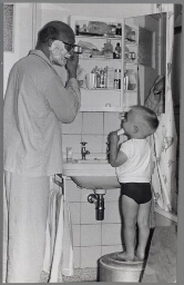 Een jongetje doet zijn vader na, terwijl die zich aan het scheren is. 195?
