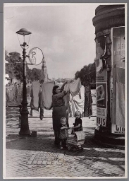 Vrouw hangt wasgoed op 1950