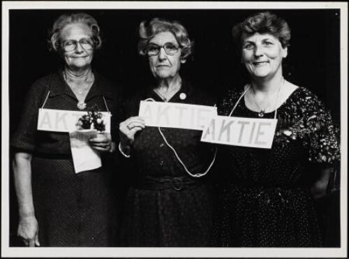 Drie vrouwen met bordjes met de tekst ' Aktie' tijdens manifestatie van de vrouwenbond. 1981