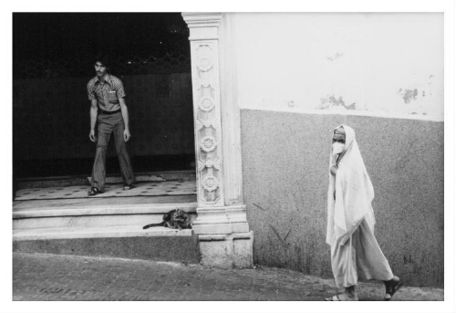 Een Algerijns gesluierde vrouwen loopt door een straat. 197?