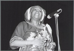 Optreden van de dichteres Celestine Raalte tijdens de manifestatie 'Memre Dubru' door Surinaamse vrouwen. 1990