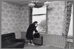 Oudere vrouw wacht voor het raam op thuiszorg. 198?